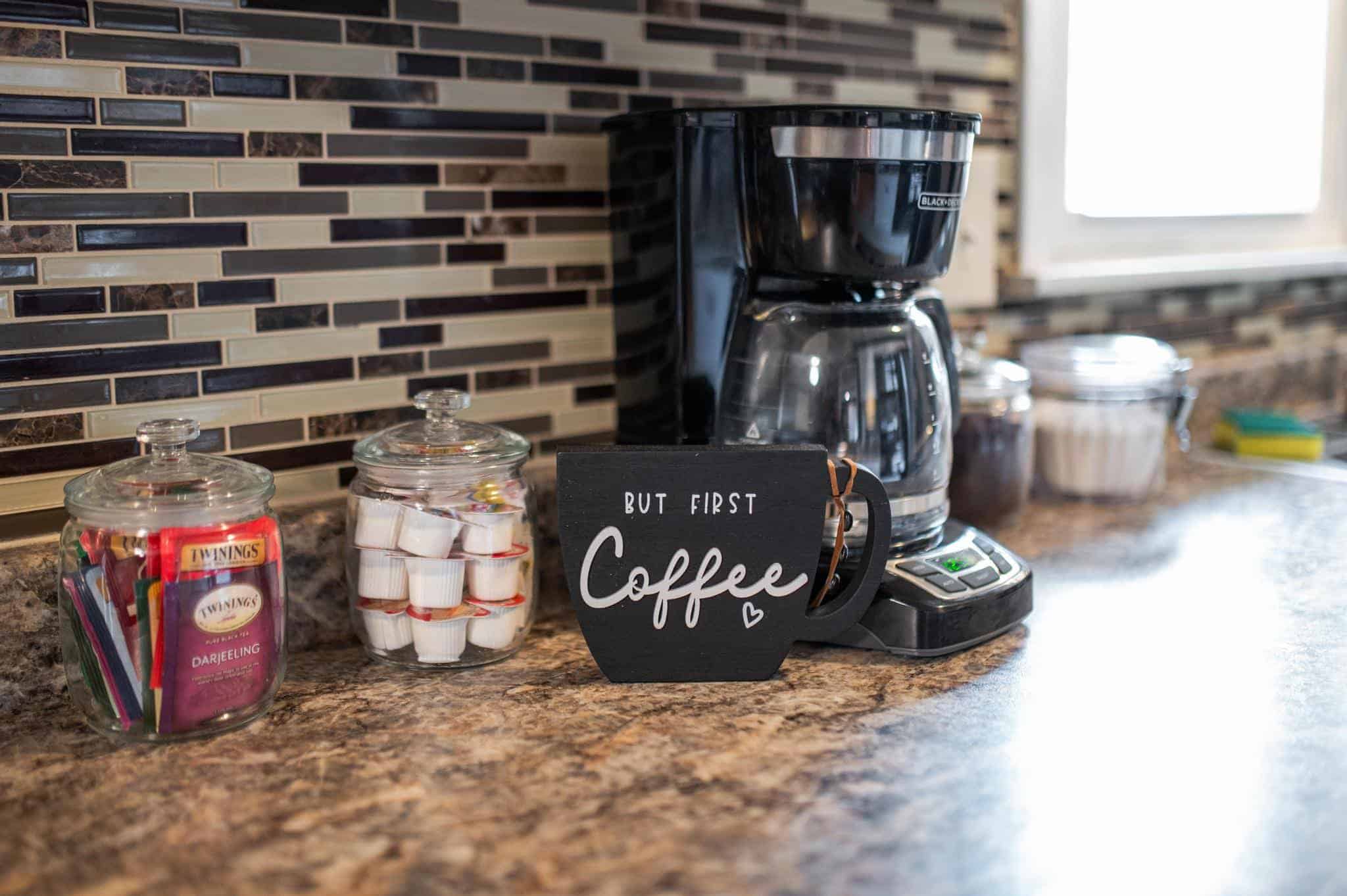 Dining Room Lees Summit Coffee station with coffee maker, cups, and supplies on kitchen countertop.