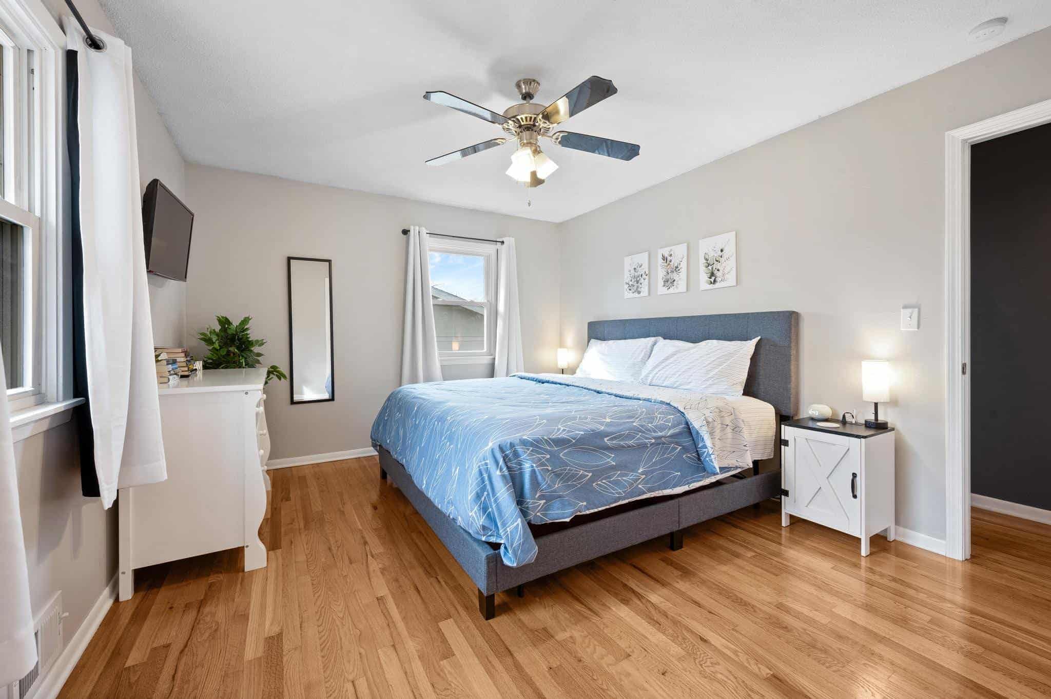 Dining Room Lees Summit Bright bedroom with large window, ceiling fan, and minimalist furniture.