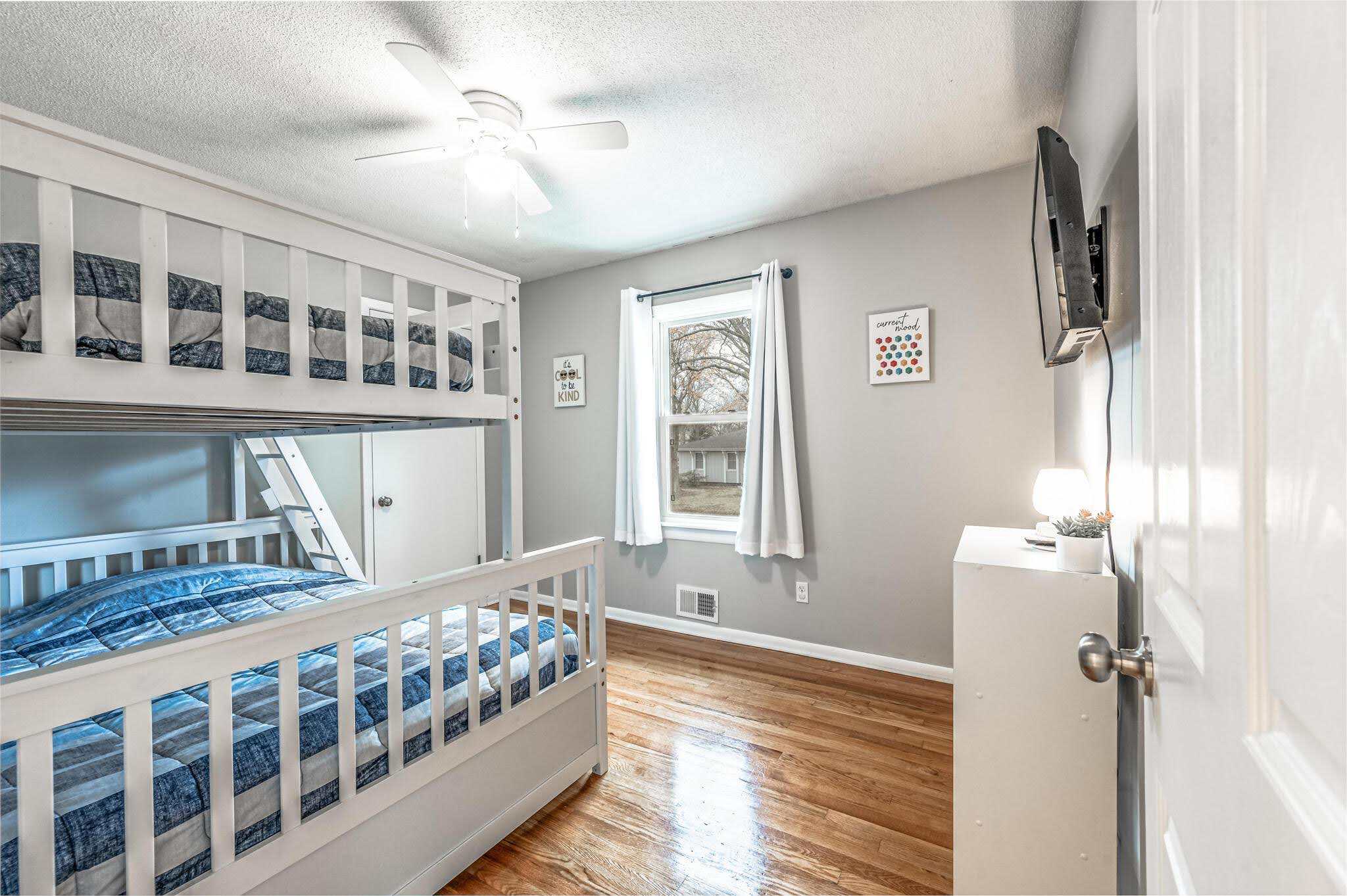 Dining Room Lees Summit Cozy bedroom with bunk beds and a window view.