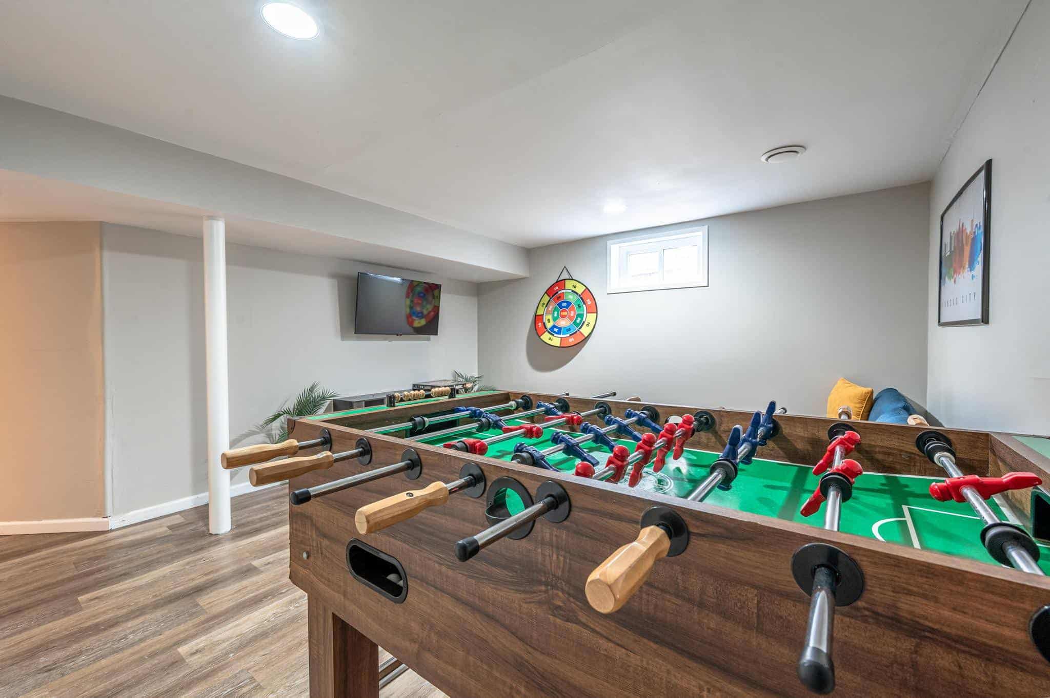 Dining Room Lees Summit Foosball table in a cozy game room with a wall-mounted TV and colorful artwork.